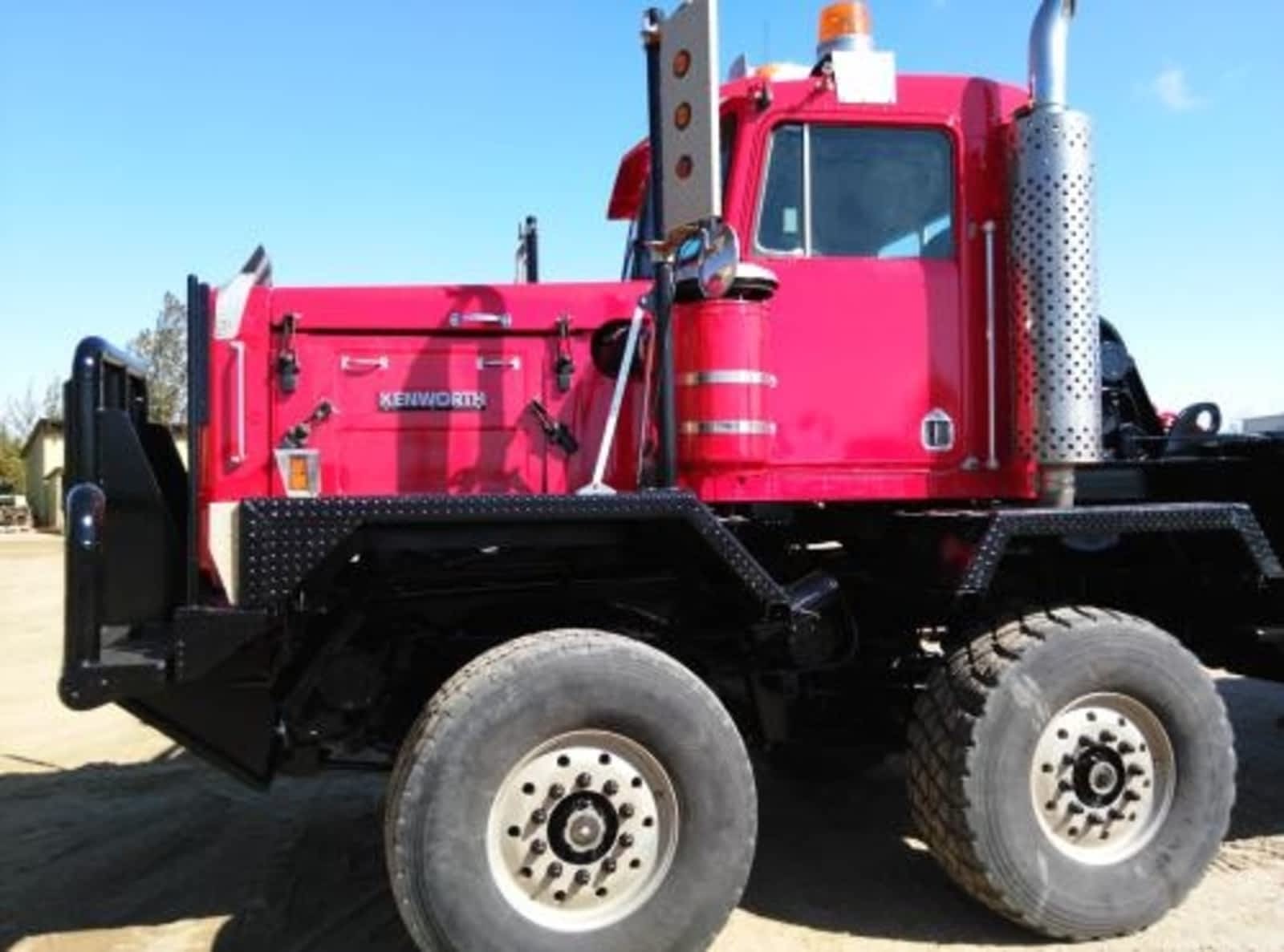 The side view of a red and black bedtruck